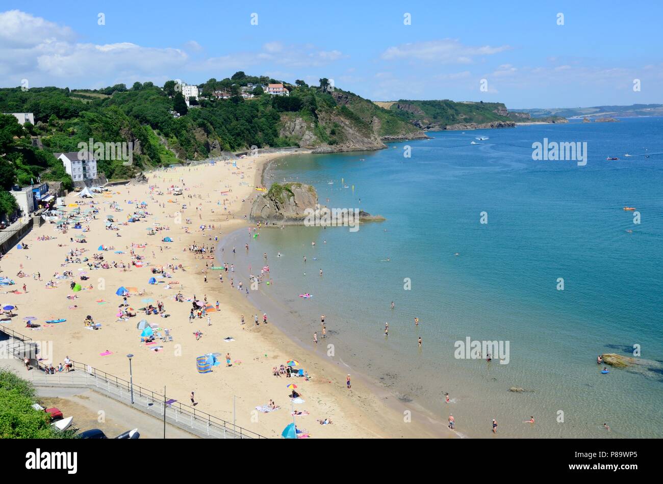 Menschen, die Touristen genießen den Sommer Sonnenschein om Tenby North Beach Pembrokeshire Wales Cymru GROSSBRITANNIEN Stockfoto