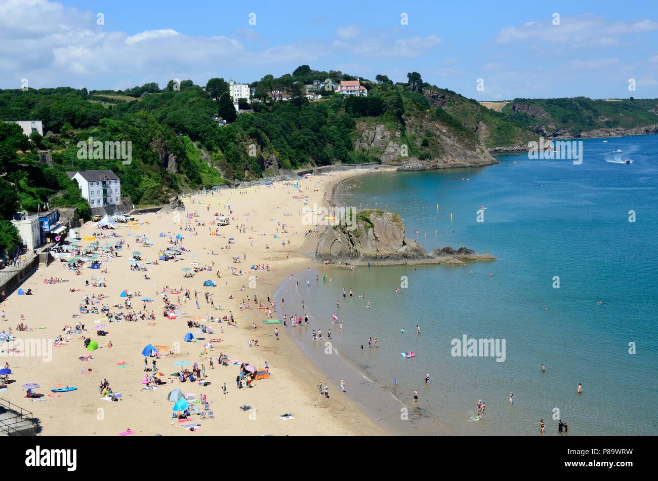 Menschen, die Touristen genießen den Sommer Sonnenschein om Tenby North Beach Pembrokeshire Wales Cymru GROSSBRITANNIEN Stockfoto