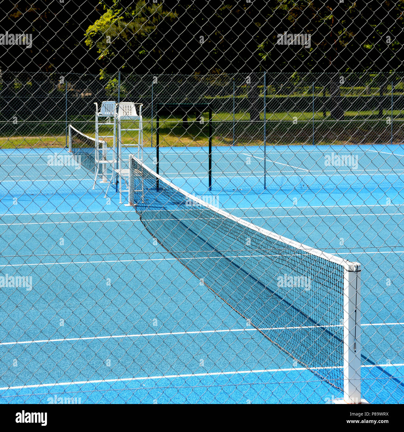 High-Angle-Aufnahme des blauen Tennisplatzes mit einem Zaun im Vordergrund Stockfoto