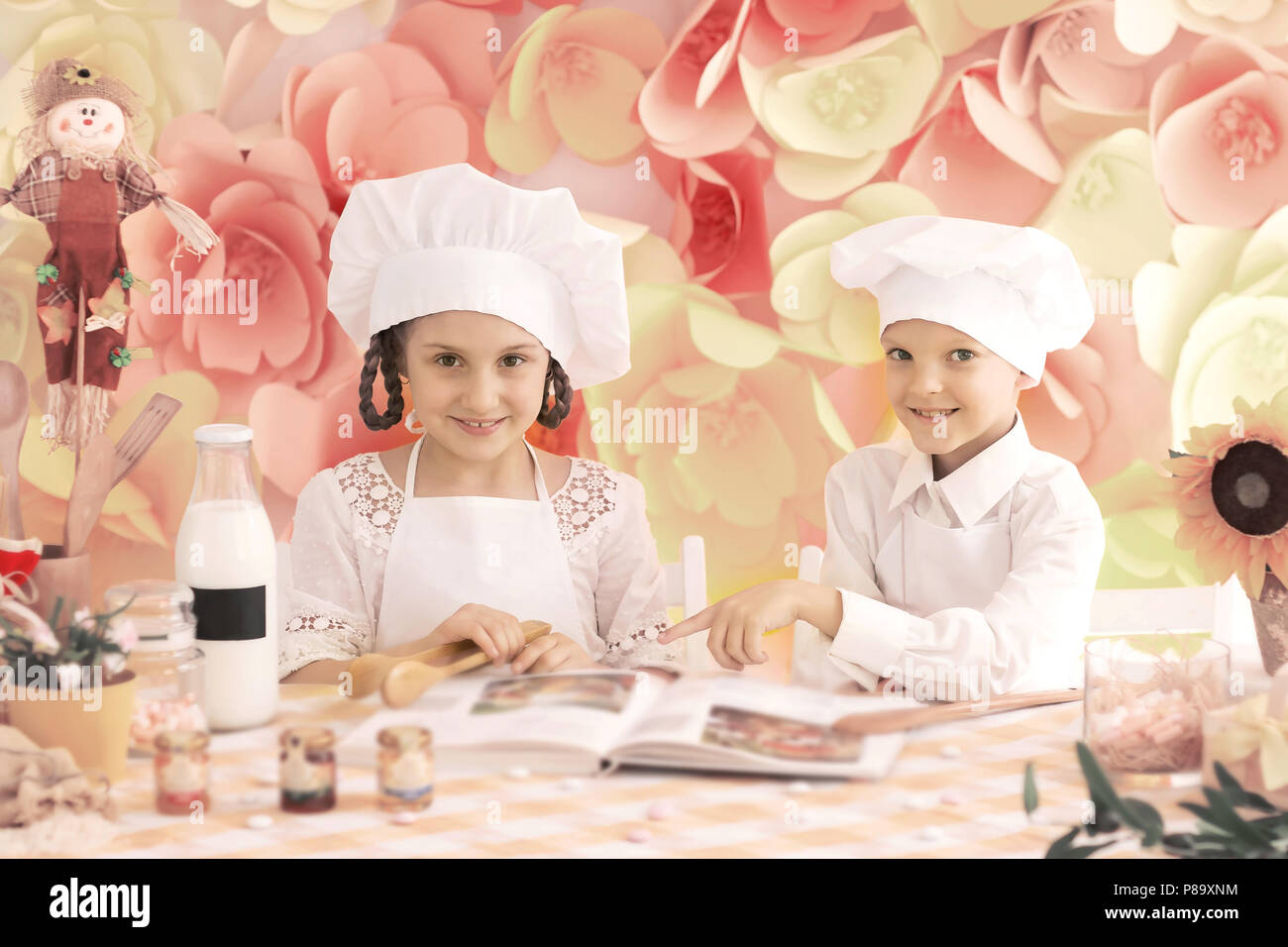 Glückliche Kinder in Form einer Küchenchef köstliche Mahlzeiten zu kochen Stockfoto