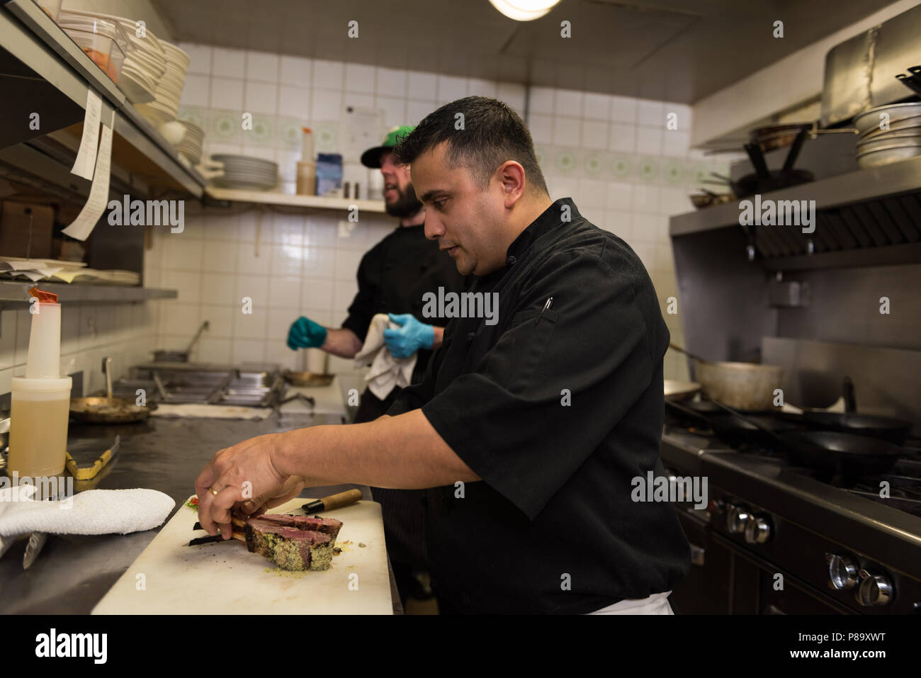 Männliche Küchenchefs Vorbereitung Huhn Stück in der Küche Stockfoto