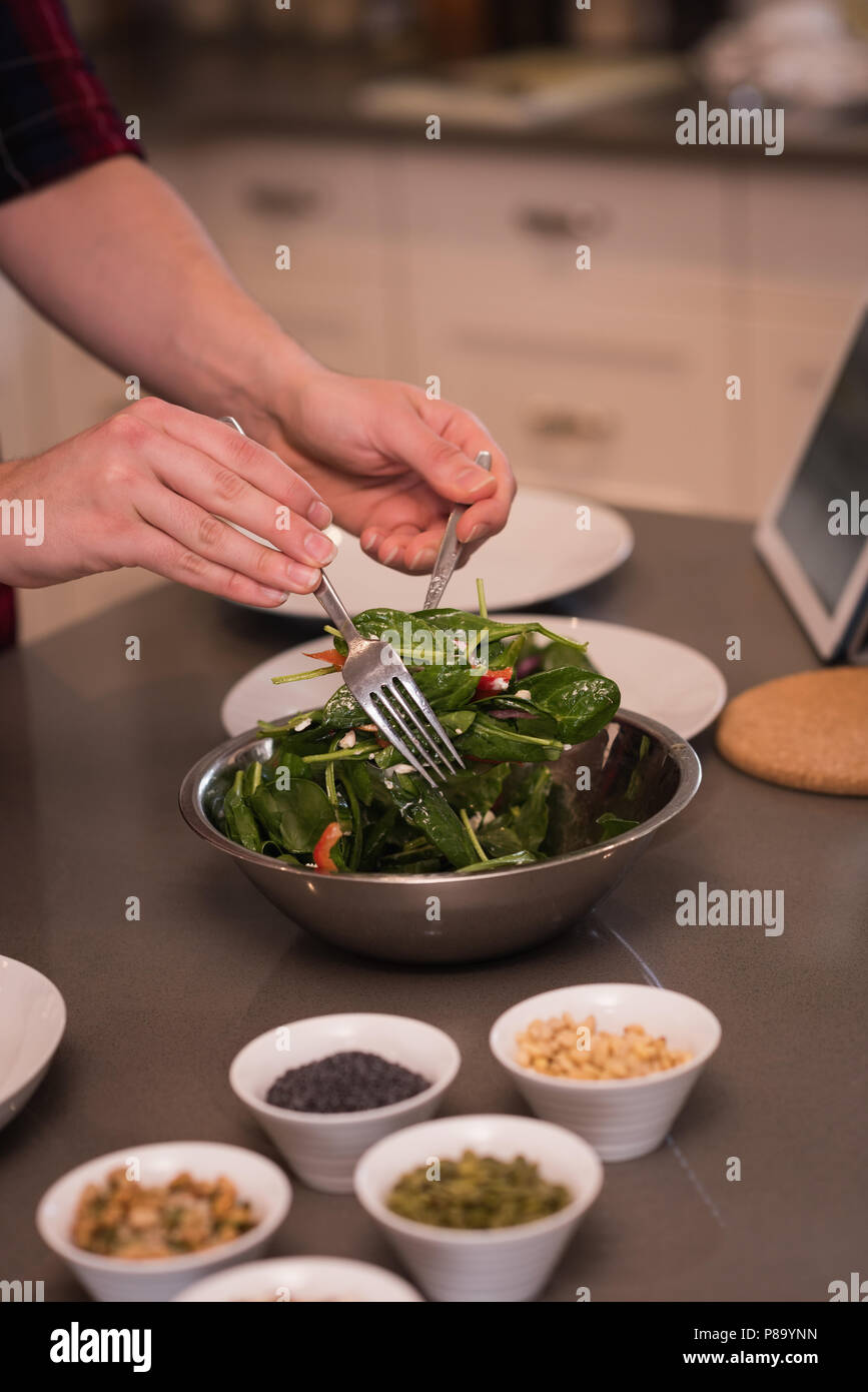 Frau bereitet Salat in Küche Stockfoto