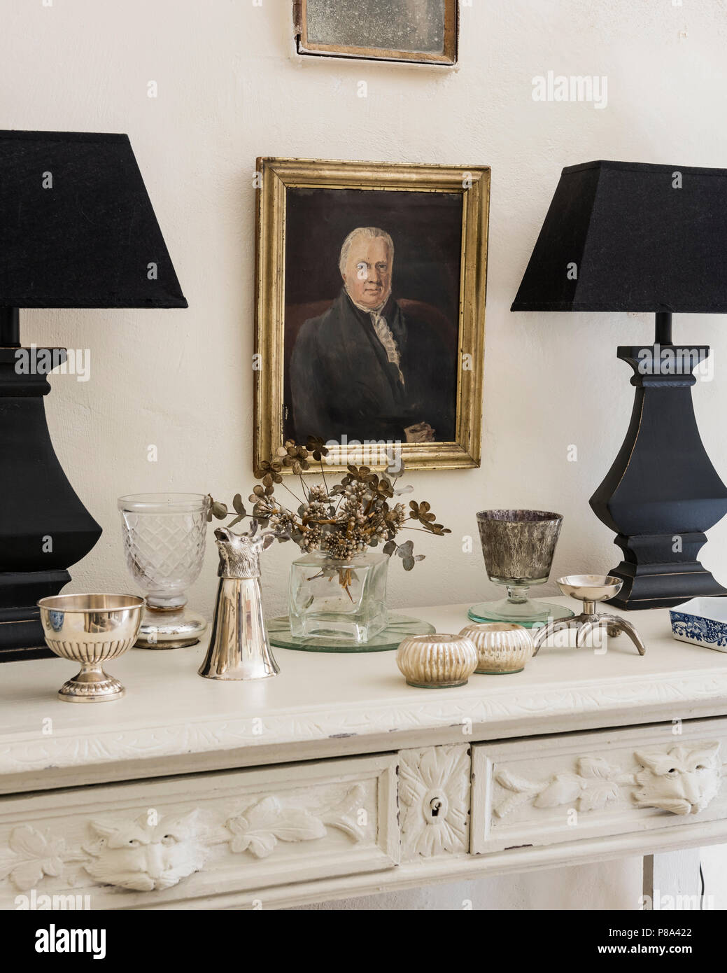 Paar schwarzer passende Lampen mit getrockneten Blumen und Besteck Stockfoto