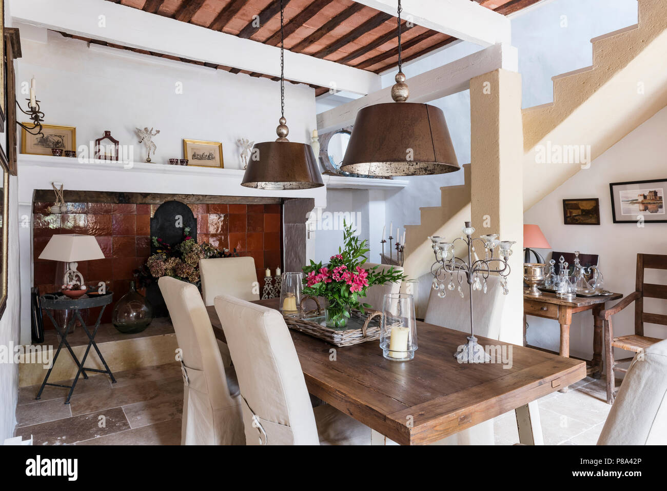 Große Metal Anhänger Lampen über dem Esstisch aus Holz mit Treppe Konvertierung Stockfoto