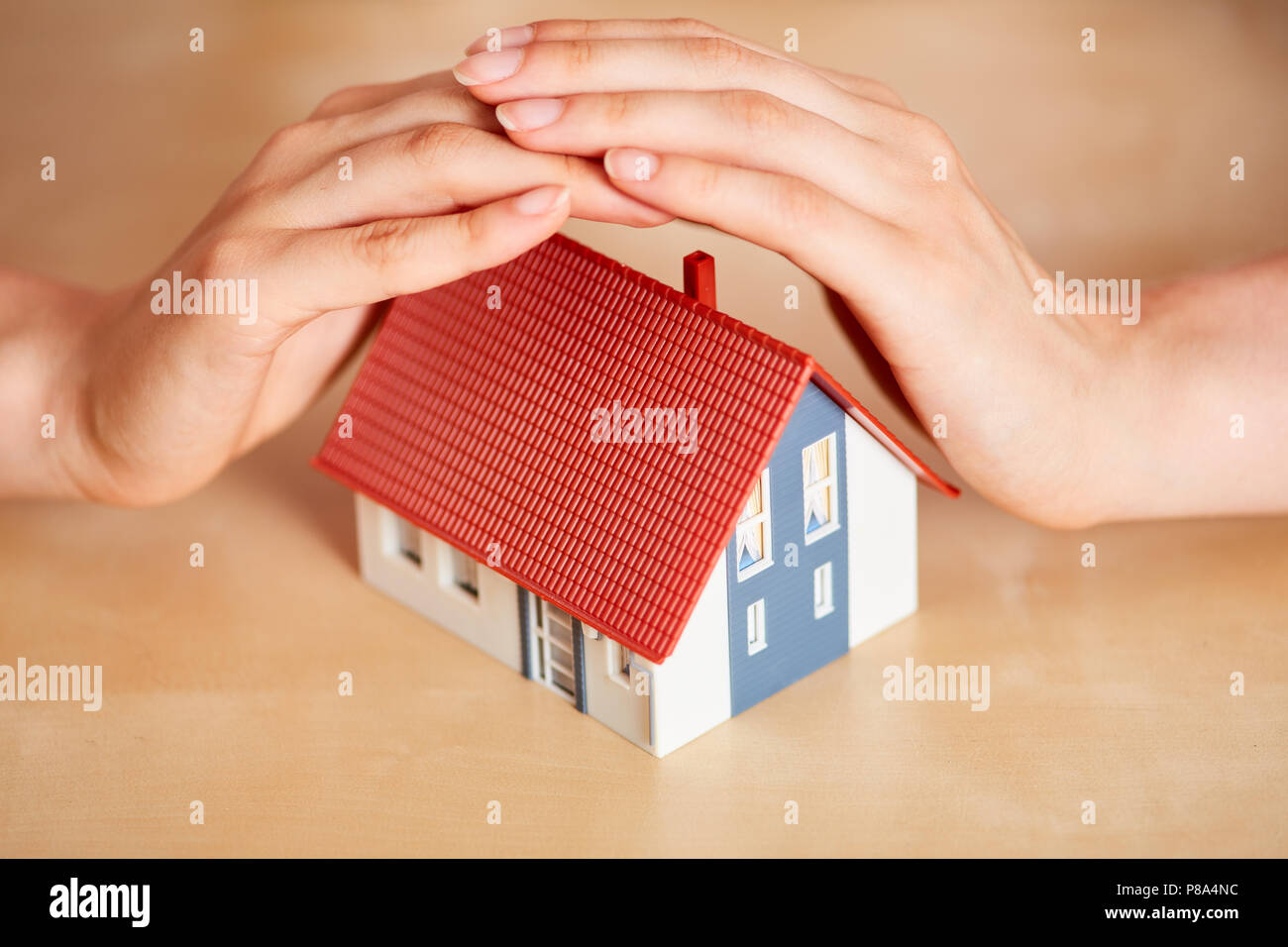 Hände schützen Ein kleines Haus wie eine gute Versicherung Stockfoto Hände schützen Ein kleines Haus wie eine gute Versicherung Stockfoto