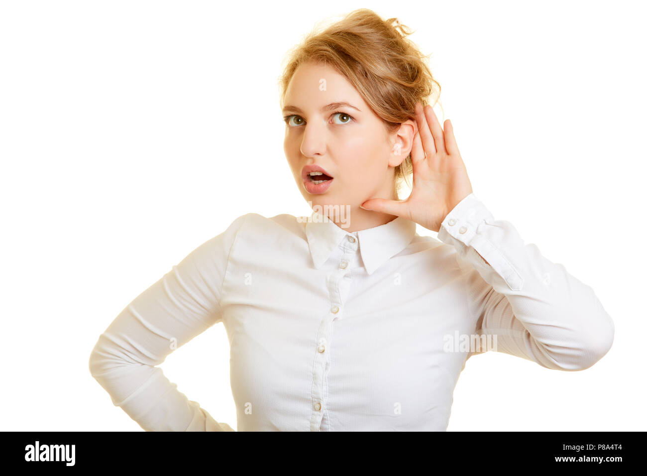 Junge blonde Frau ist anstrengend eine Hand hinter Ihr Ohr während der Wiedergabe Stockfoto