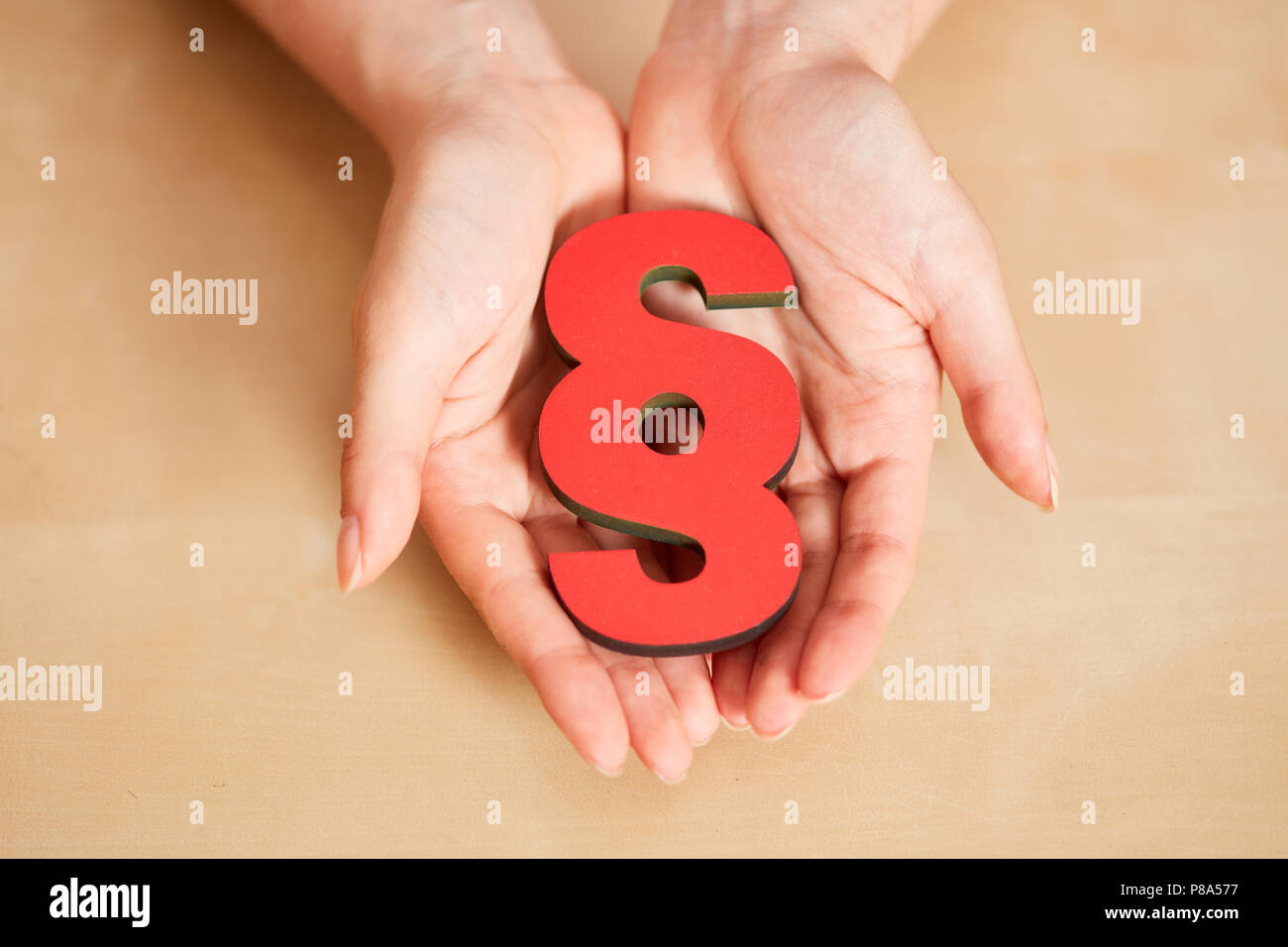 Zwei Hände halten einen roten Absatz als Recht und Gesetz Konzept Stockfoto