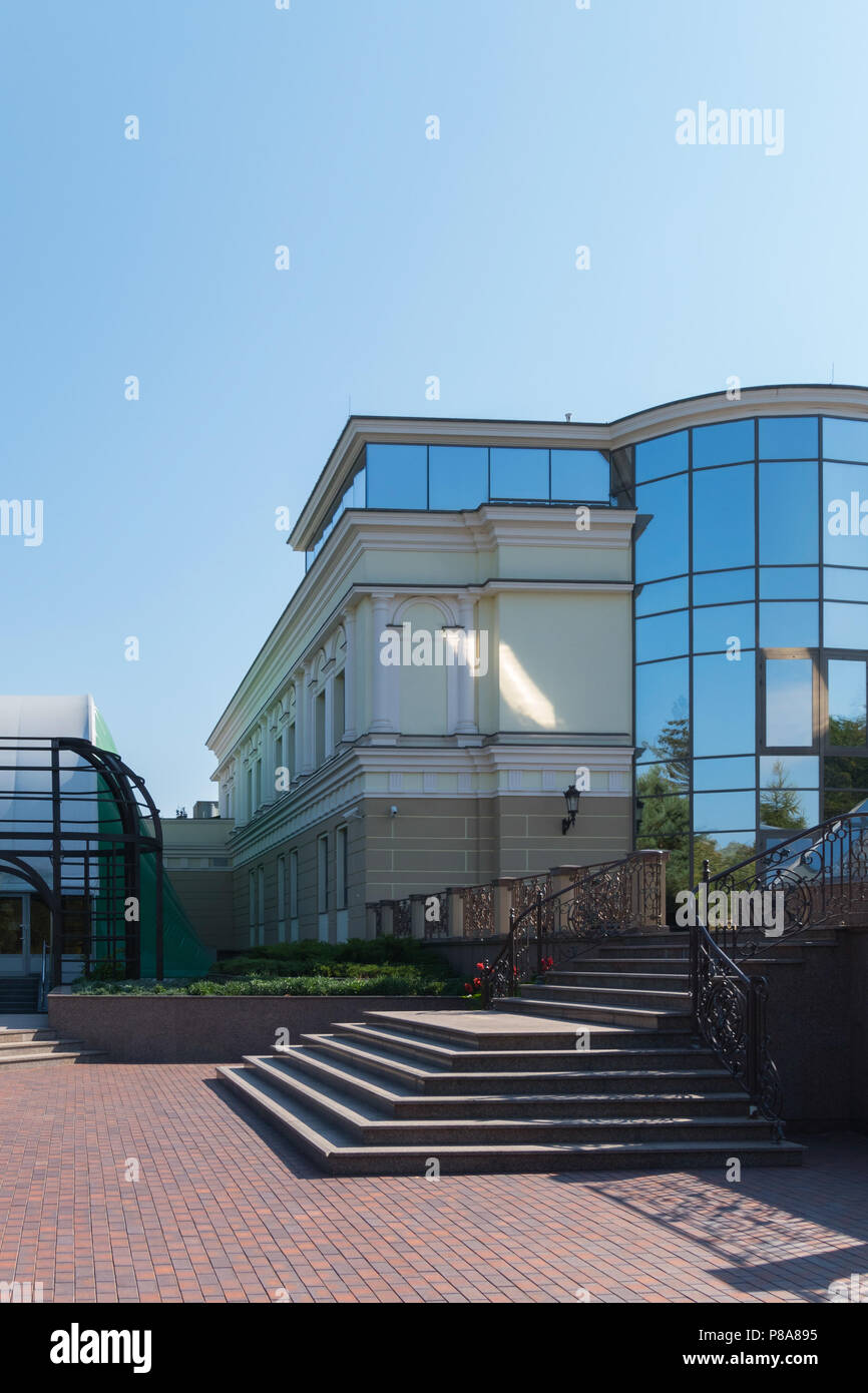 Die Fassade des Gebäudes mit breiten Stufen der Treppe, die zum Eingang mit verspiegeltem Glas. . Für ihr Design Stockfoto