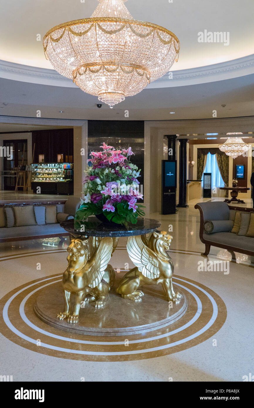 Eine große Lobby, eine geräumige Halle mit einem riesigen Kronleuchter aus Kristall, teure Möbel, einen Tisch für Blüten mit goldenen Greife. Für ihr Design Stockfoto