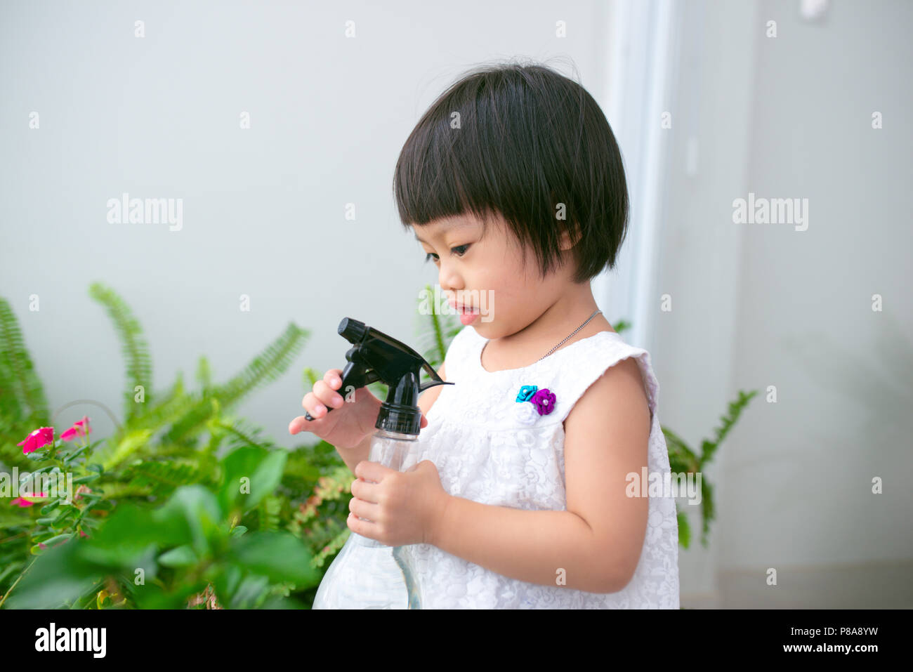 Kind die Pflege von Pflanzen. Süße kleine Mädchen Bewässerung ersten Frühling Blumen Stockfoto