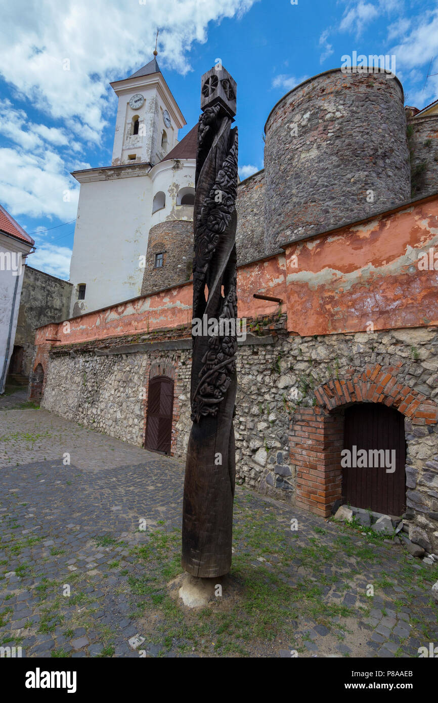 Eine alte von Zeit Holz- Säule mit einem Rand von bizarren Muster bedeckt geschwärzt. Im Innenhof eines alten Festung. . Für Ihre des Stockfoto