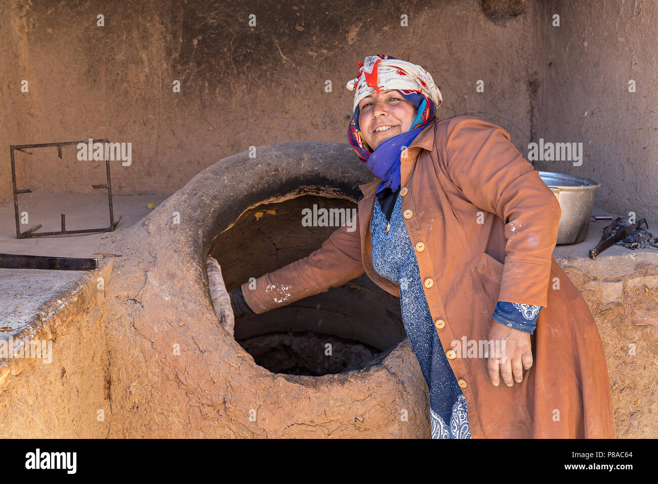 Lokale Frau, die Brot im Tandoor Ofen backen, in Rayen, Iran. Stockfoto