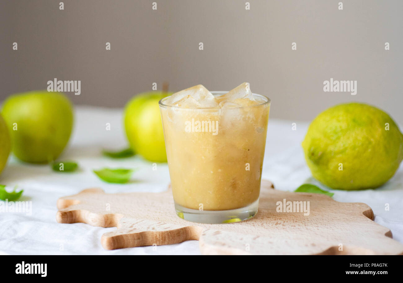 Frisch blended green Fruit Smoothie in einem Glas über weiße Tischtuch Hintergrund. Mixer, grüne Äpfel, Limette und Minze. Detox, sauber Essen, Diät wei Stockfoto