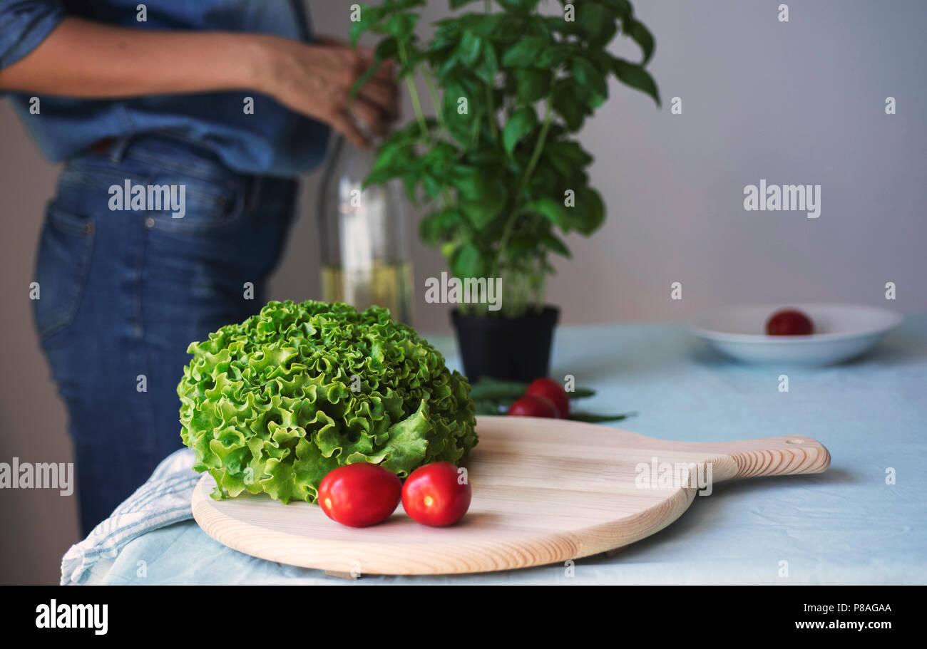 Junge Frau in Jeans Kochen gesund vegetarisch detox Essen. Zutaten und Zubereitung für gesunde italienische Küche Stockfoto