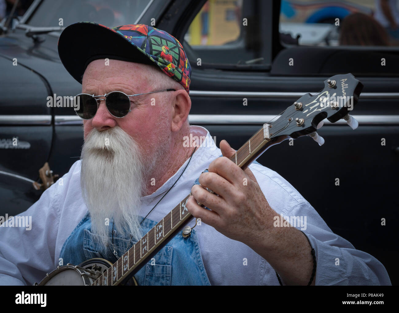 Mann mit langen Spitzbart und Schnurrbart spielen Banjo. Stockfoto