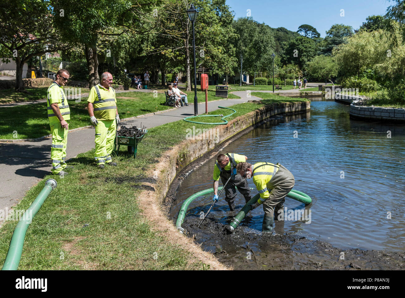 Arbeitnehmer mit einer Saugpumpe Schlamm und Schlick in einem See zu entfernen. Stockfoto