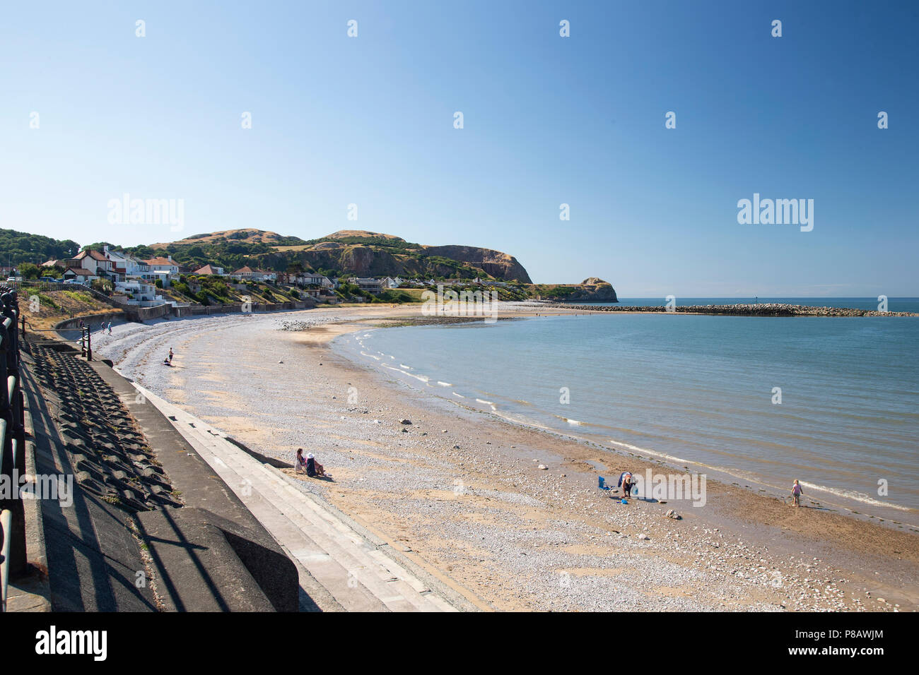 Der Strand von Penrhyn Bay, North Wales mit dem Little Orme Kalkstein Landspitze in der Ferne Stockfoto