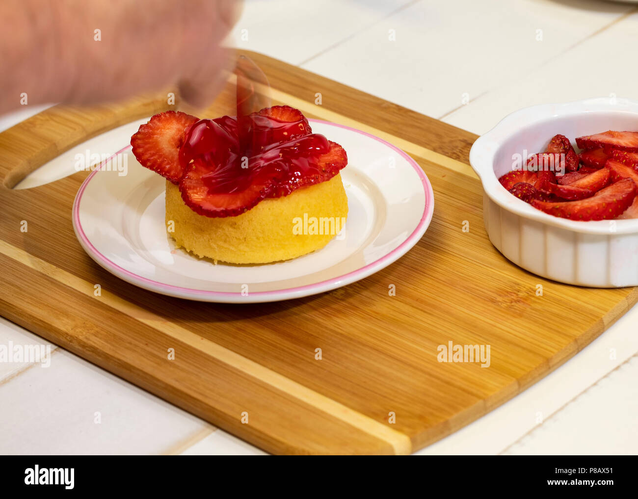 Vorbereitung shortcake Dessert mit frischen Erdbeeren, Blaubeeren, und Schlagsahne. Stockfoto