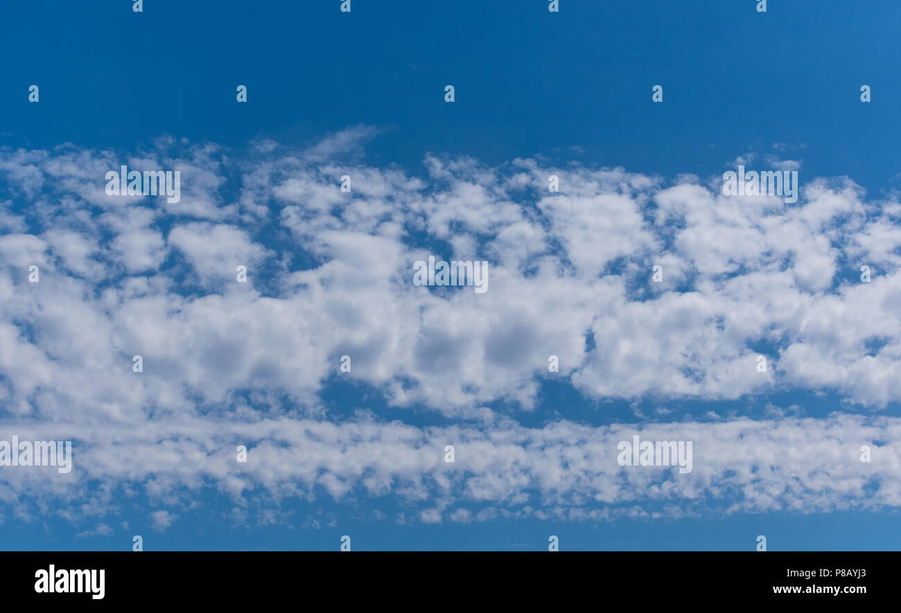 Reihen von weißen geschwollene Wolken über dem Hintergrund eines wunderschönen Farbton des blauen Himmels Stockfoto