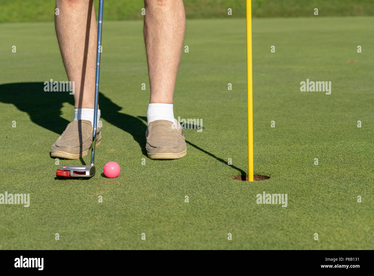 Rosa Golf ball von Flagge und Loch Putting Green Stockfoto