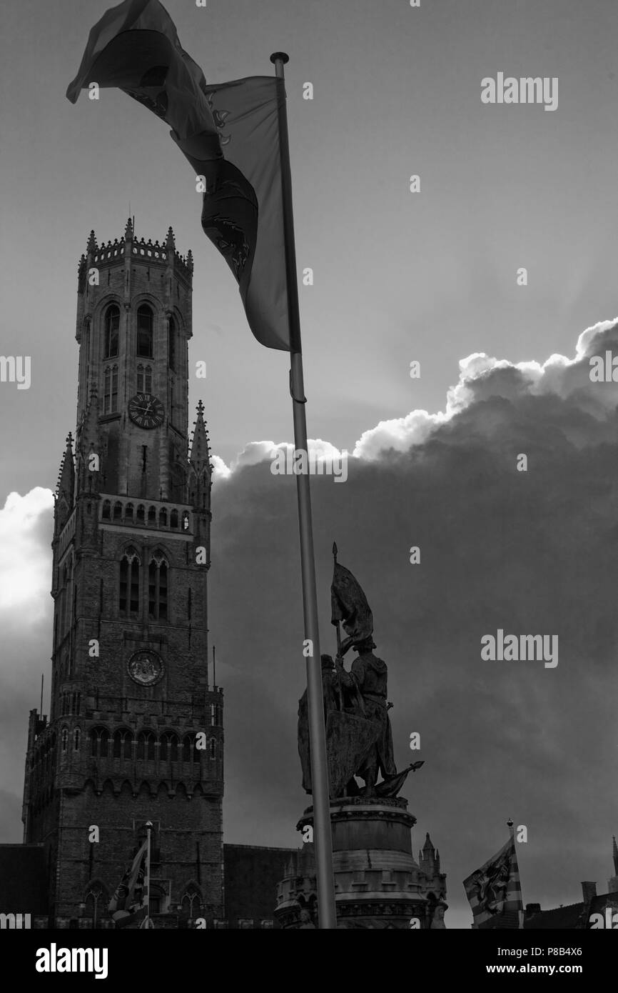 Die hohen gotischen Belfort, oder Glockenturm der Hallen in den Markt, Brugge, Belgien, mit Fahnen und Statue. Schwarz und Weiss Stockfoto