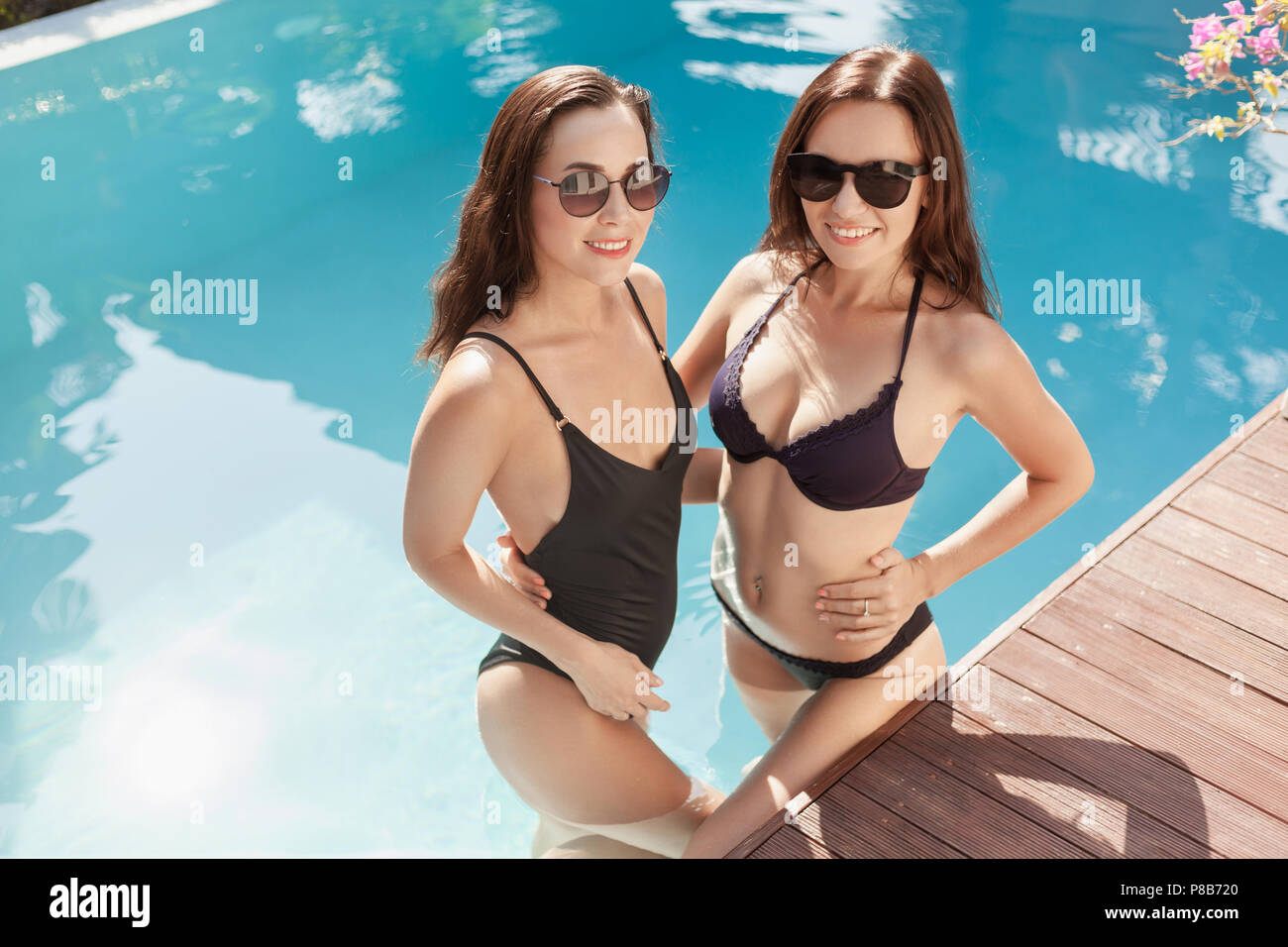Attraktive junge Frauen in Bikini und Badehose in Pool Stockfotografie -  Alamy
