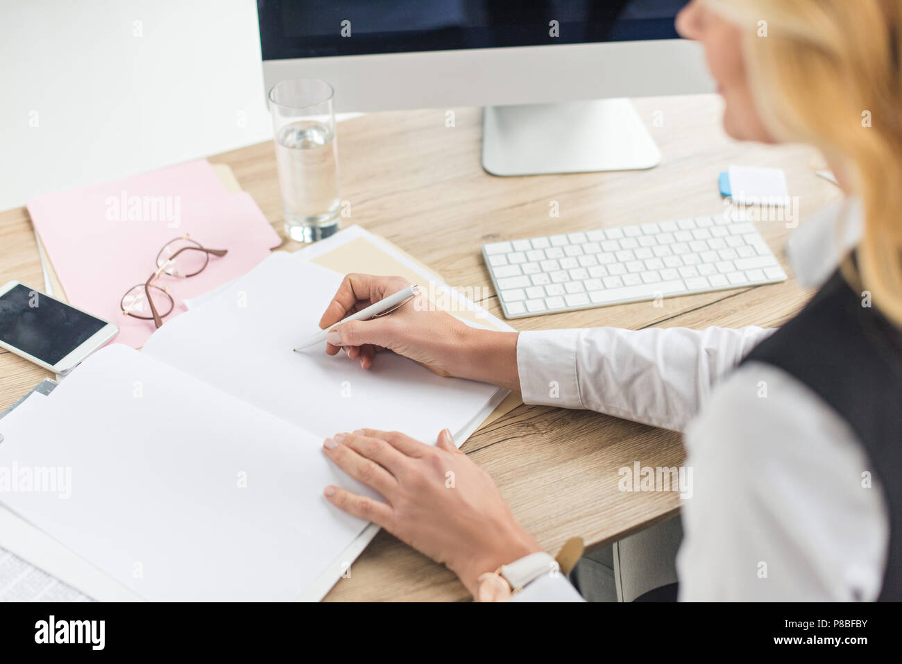 Schuss Geschäftsfrau Schreibarbeit tun am Arbeitsplatz 7/8 Stockfoto
