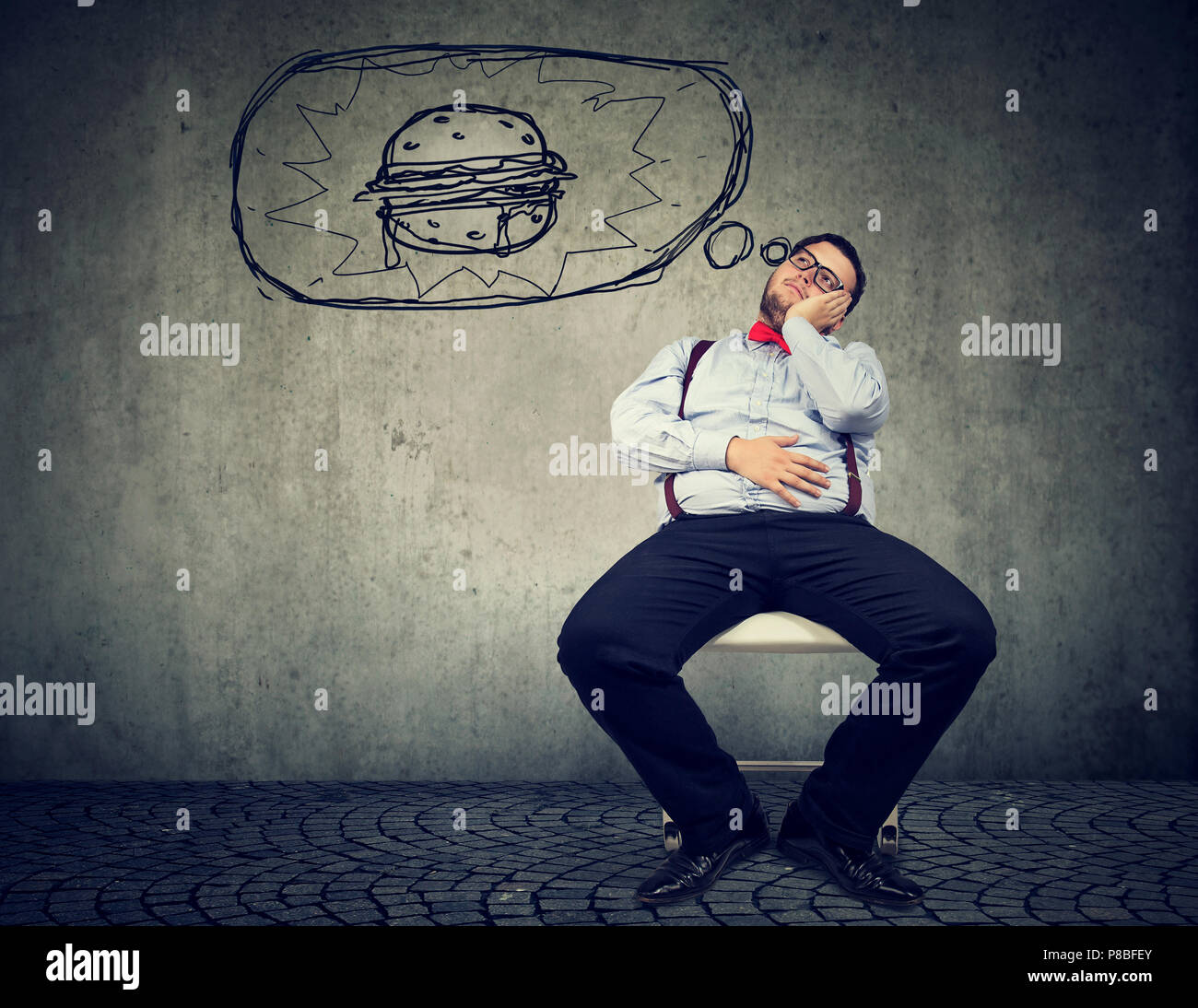 Hungrige Fett business Mann sitzt auf Stuhl träumen von einem Burger Stockfoto