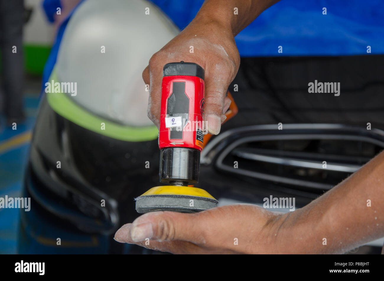 Mann hält eine poliermaschine Auto Scheinwerfer Stockfotografie - Alamy