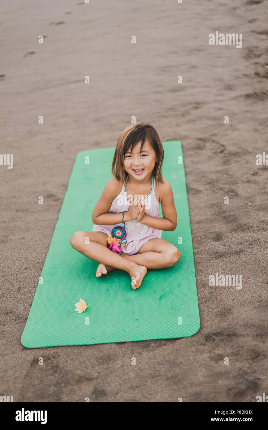 Adorable Kleine Kind Uben Yoga Auf Der Matte Im Lotussitz Mit Namaste Mudra Am Sandstrand Stockfotografie Alamy