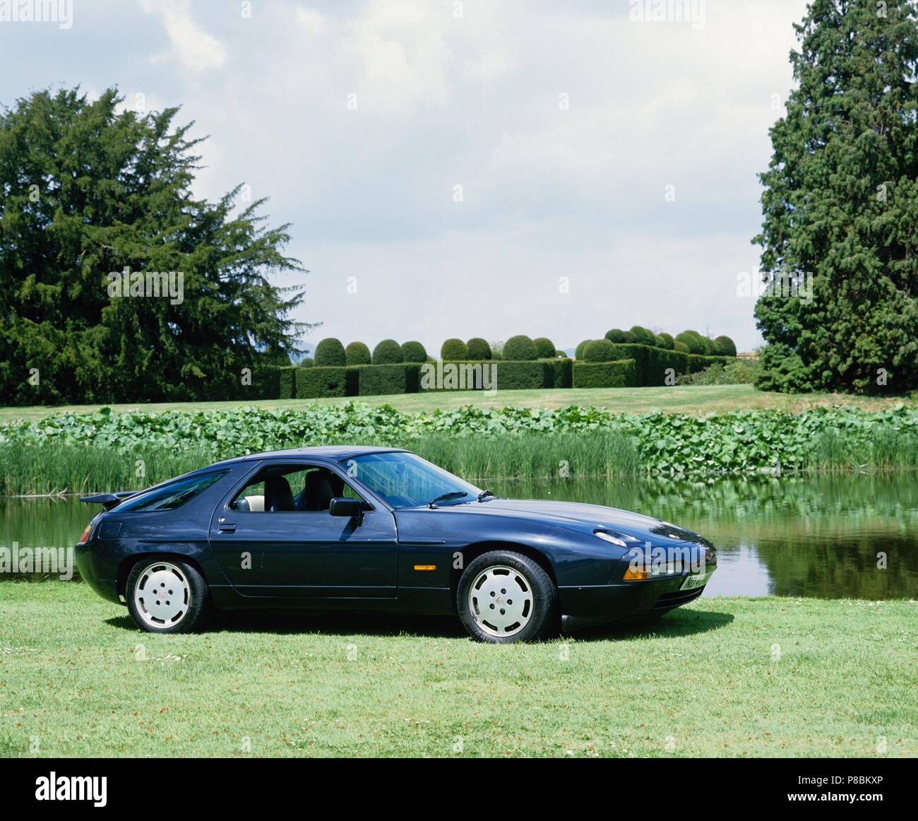 Porsche 928 S4 1988 Modell Jahr - Seitenansicht in einem üppigen Garten Landschaft Stockfoto