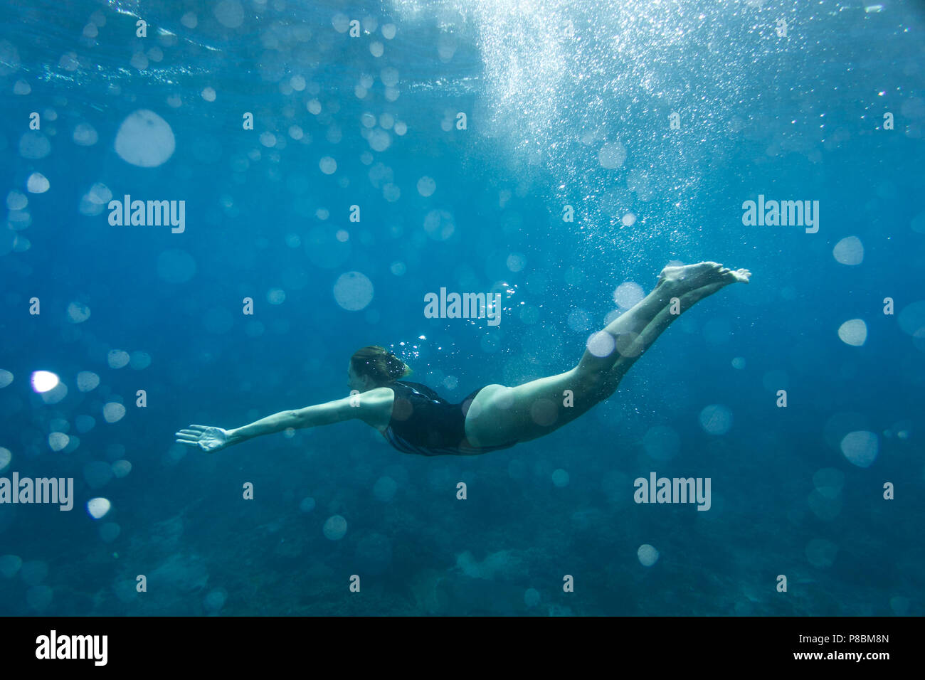Unterwasser Foto der jungen Frau im Badeanzug Tauchen im Meer allein Stockfoto