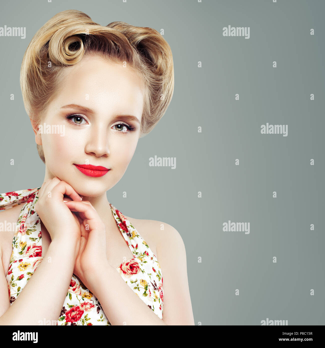 Mode Porträt der schönen Frau mit Retro Vintage Pinup Frisur und Make-up gegen graue Wand Hintergrund Stockfoto