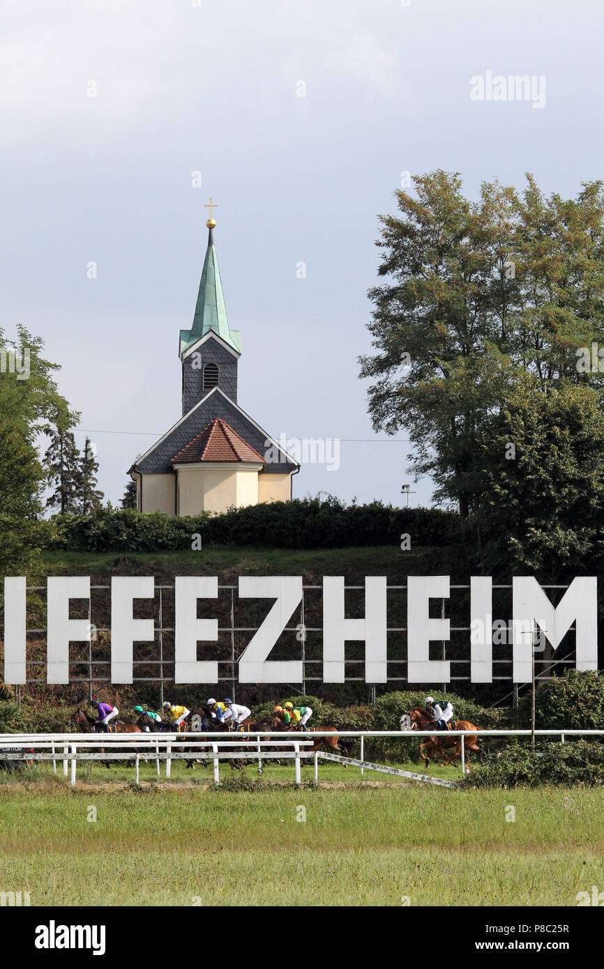 Iffezheim, Pferde und Jockeys in das Rennen vor dem Iffezheim Logo unter der Kapelle Stockfoto