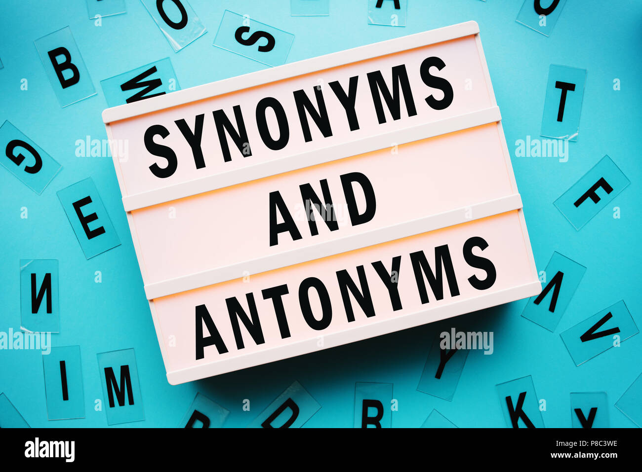 Synonyme und Antonyme Konzept mit Buchstaben und Lightbox Stockfoto