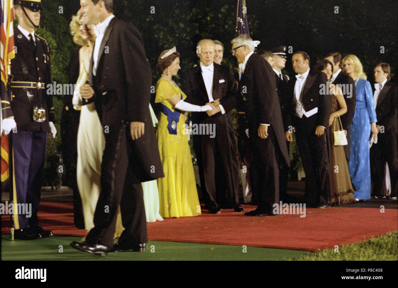 1976, 7. Juli - South Auffahrt - das Weiße Haus - Washington, DC - Gerald R. Ford, Queen Elizabeth II, Henry Catto; Cary Grant; Gäste - Begrüßung, Händeschütteln, stehen, reden; die Gäste in der Linie auf der rechten Seite des Rahmens; lange Schuß von South Lawn; weiße Krawatte formale Abnutzung - Empfang vor dem Staat Abendessen zu Ehren von Königin Elizabeth II. und Prinz Philip - Englisch US-amerikanischer Schauspieler Stockfoto