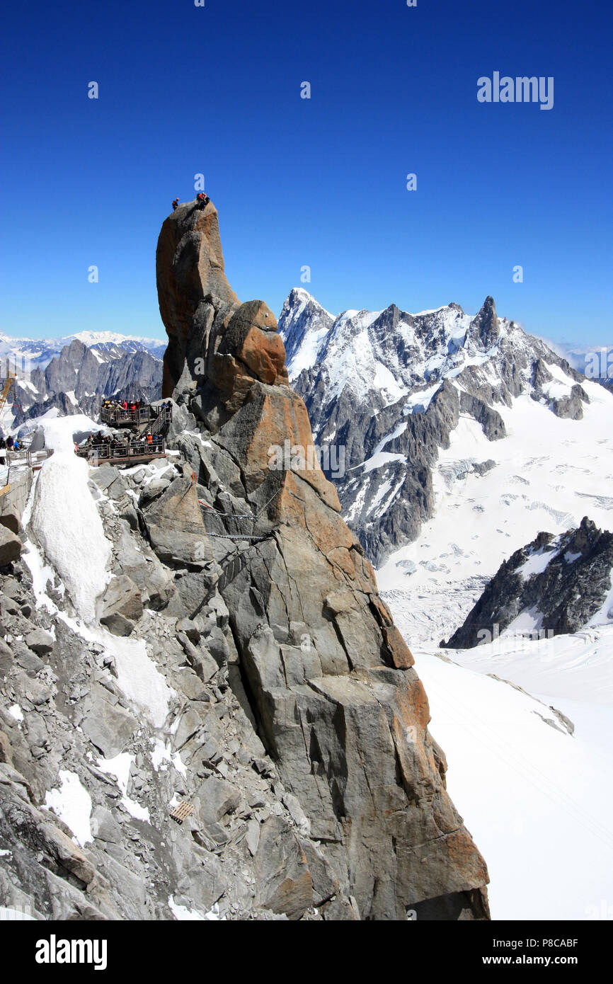 Kletterer auf der Spitze eines Pinnacle während Touristen beobachten Von den aussichtsplattformen an der Aiguille-du-Midi in Frankreich Stockfoto