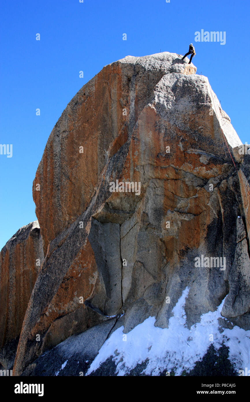 Ein Kletterer auf eine beeindruckende Felsen neben den Gipfel der Aiguille-du-Midi in das Mont Blanc Massiv, Frankreich Stockfoto