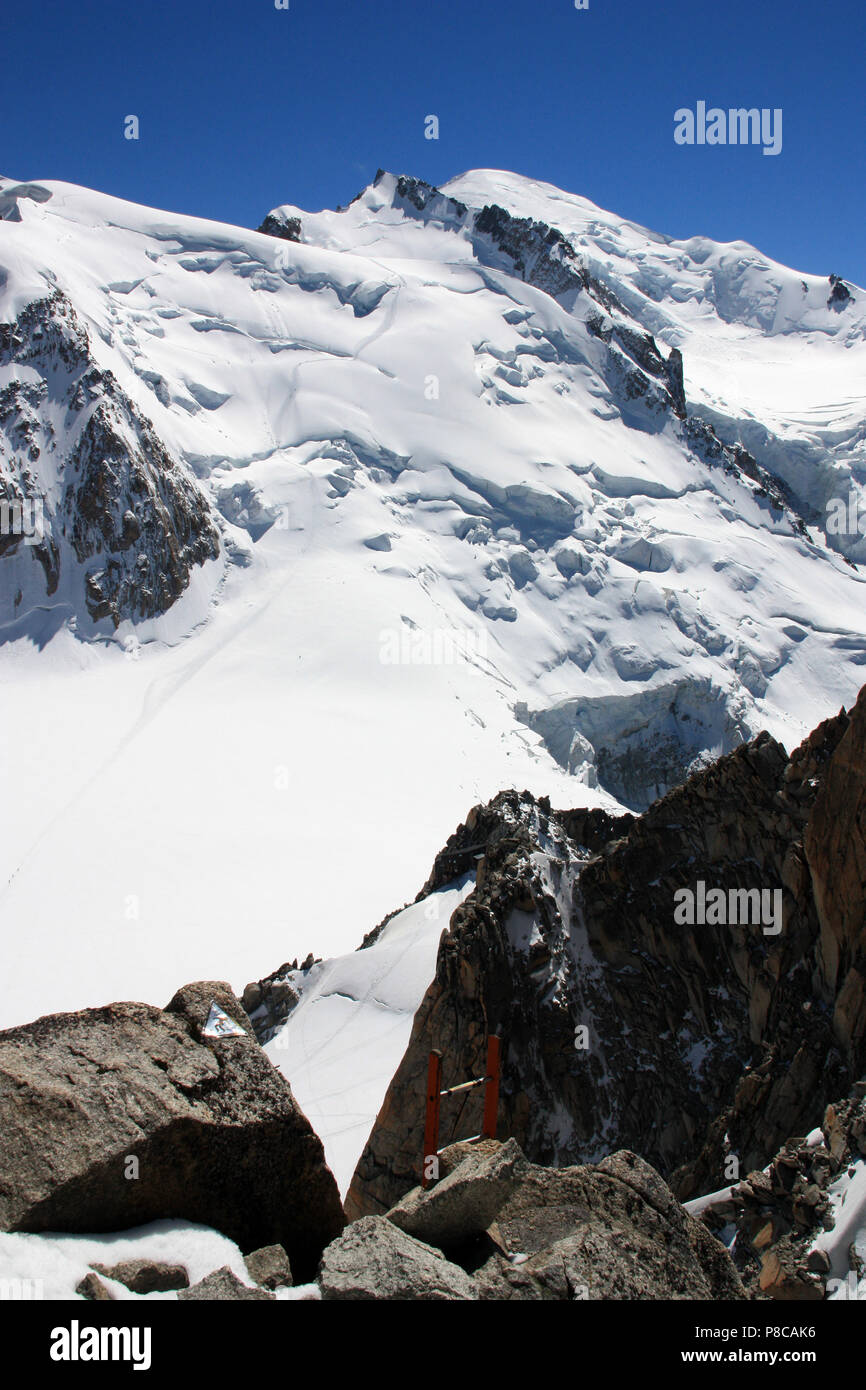 Jeder braucht eine kleine Hilfe: Leiter an die Spitze der Aiguille du Midi in Frankreich (mit dem Mont Blanc im Hintergrund) Stockfoto