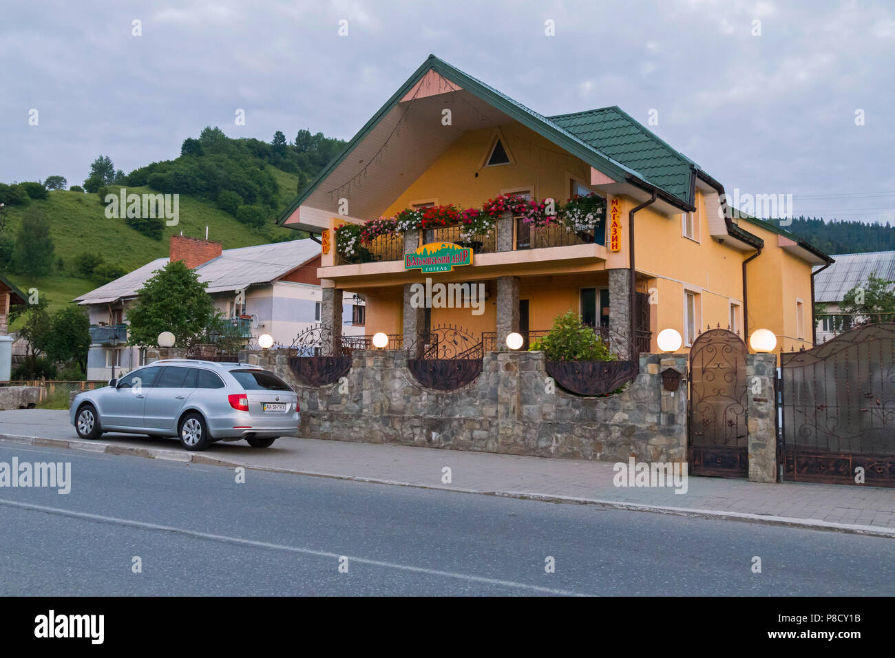 Ein Auto der Reisende in der Nähe eines kleinen schickes Hotel in einem großen privaten Haus gemacht. Mit einer schönen Blume Bett mit Blumen auf dem Balkon Stockfoto