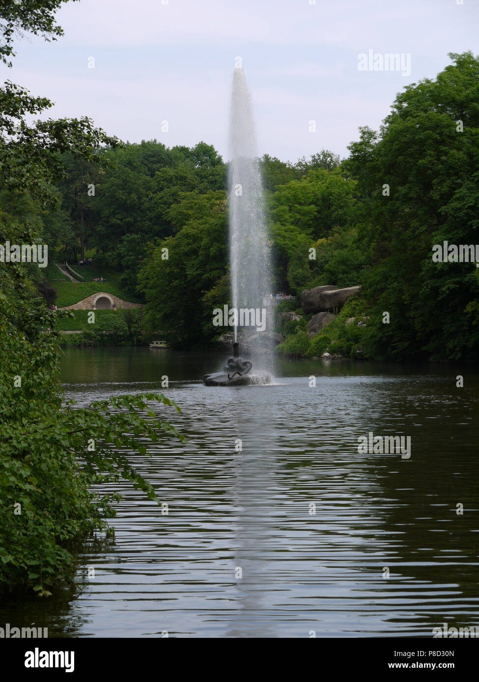 Ein großer Springbrunnen in der Mitte des Sees vor dem Hintergrund der schönen, gepflegten Rasenflächen und grüne Bäume. Für ihr Design Stockfoto