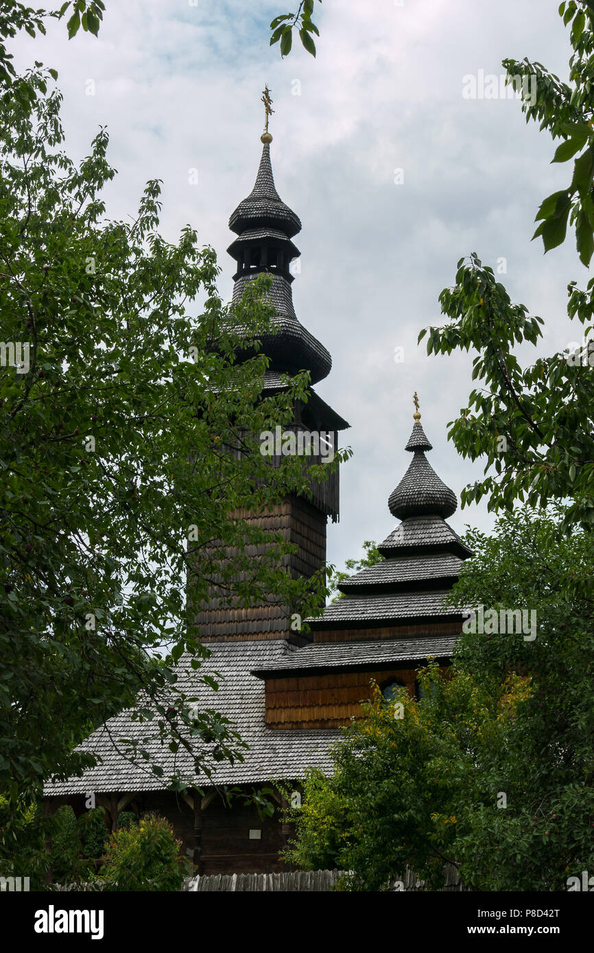 Eine alte Kirche mit hölzernen Kuppeln in Transkarpatien in einem grünen Park. Für ihr Design Stockfoto