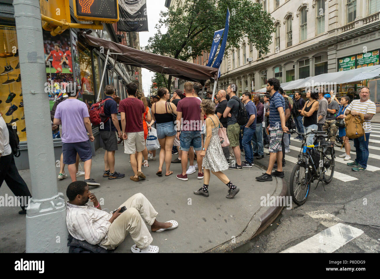Begeisterte Fußball (Fußball) Fans beobachten Belgien beat Brasilien 2-1 bei einem Behelfsmäßigen 'Theater' auf dem Bürgersteig außerhalb des Paragon Sportfachgeschäft in der Union Square in New York am Freitag, 6. Juli 2018. (© Richard B. Levine) Stockfoto