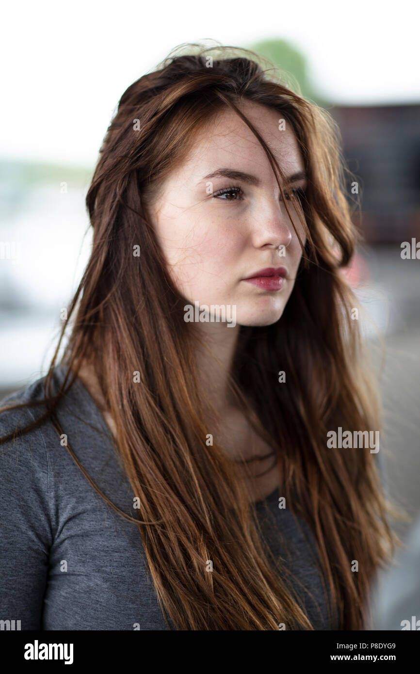 Portrait der Gesicht einer hübschen Mädchen stehen im Freien. Selektive konzentrieren. Medium close up. Winkel betrachten. Stockfoto