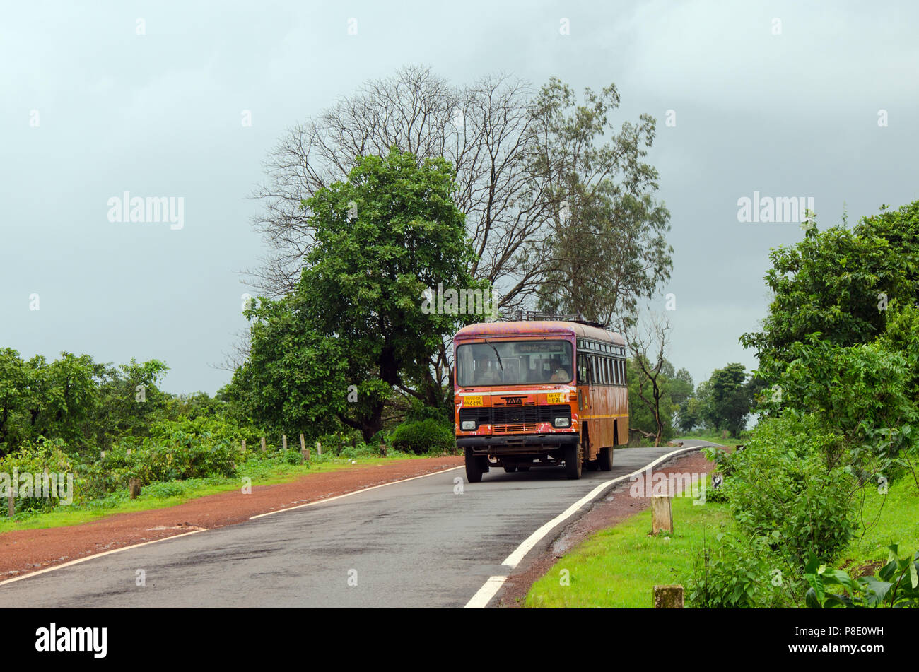 Classic, gewöhnlichen roten Bus Der MSRTC (Maharashtra State Road Transport Corporation) auf einer schmalen Straße durch eine landschaftlich reizvolle Strecke. Stockfoto