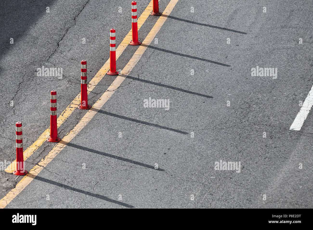 Gelbe doppel Trennlinie und rotem Kunststoff Warnung Polen über graues Landstraße Asphalt Stockfoto