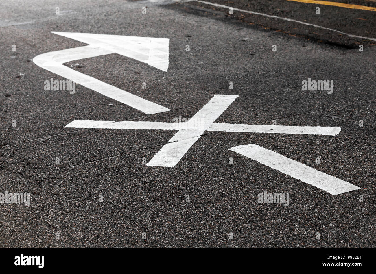 Rechts ist verboten. Weißer Pfeil, Straßen Markierung über schwarze Landstraße Asphalt gekreuzt. Nahaufnahme mit selektiven Fokus Stockfoto