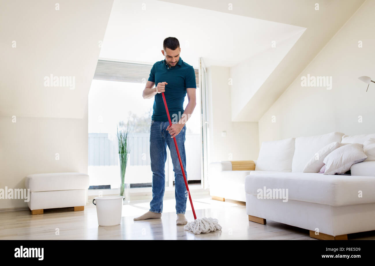 Mann mit Wischmopp und Eimer Reinigung Boden zu Hause Stockfoto