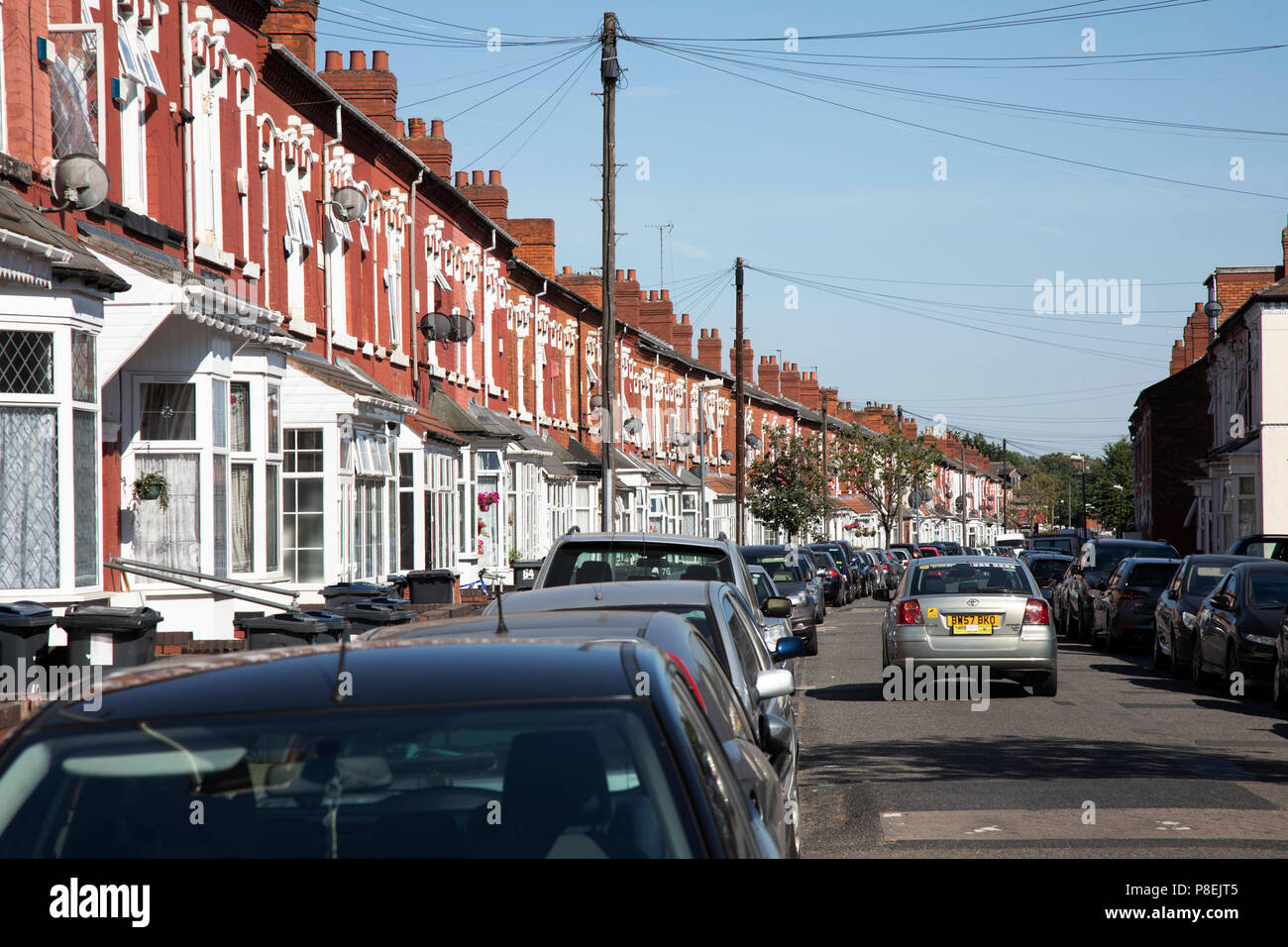 Reihenhäuser auf Ombersley Straße in Sparkbrook, Birmingham, Vereinigtes Königreich. In der Architektur und Stadtplanung, ein Reihenhaus oder eine Terrasse Haus oder Reihenhaus Exponate einen Stil von mittlerer Dichte Gehäuse, das in Europa im 16. Jahrhundert entstanden, wo eine Reihe von identischen oder spiegelbildlichen Häuser teilen Seitenwänden. Stockfoto