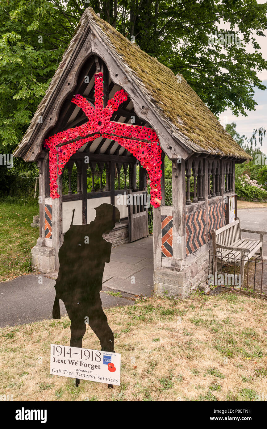 Kirche St. Maria Magdalena, Eardisley, Herefordshire, UK. Handgestrickte rote Mohnblumen schmücken die lychgate den 100. Jahrestag des Ersten Weltkriegs zu markieren Stockfoto